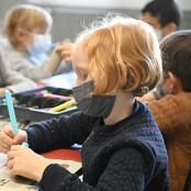 Ecolière avec un masque tenant un feutre